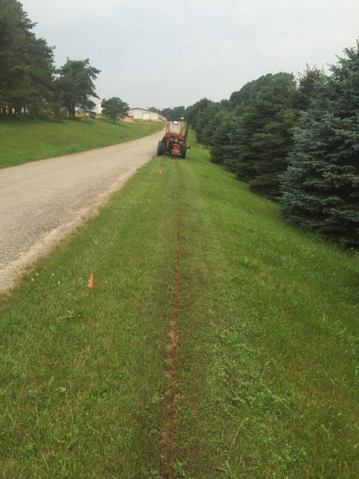 Trencher laying tubing and gas pipe